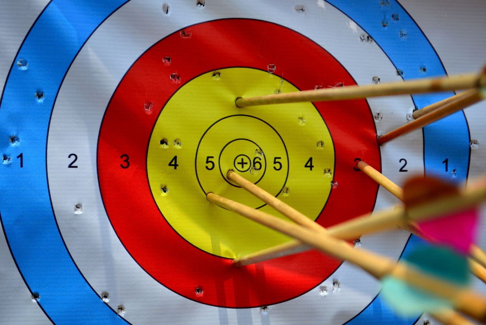 Arrows in the bullseye of a colourful archery target