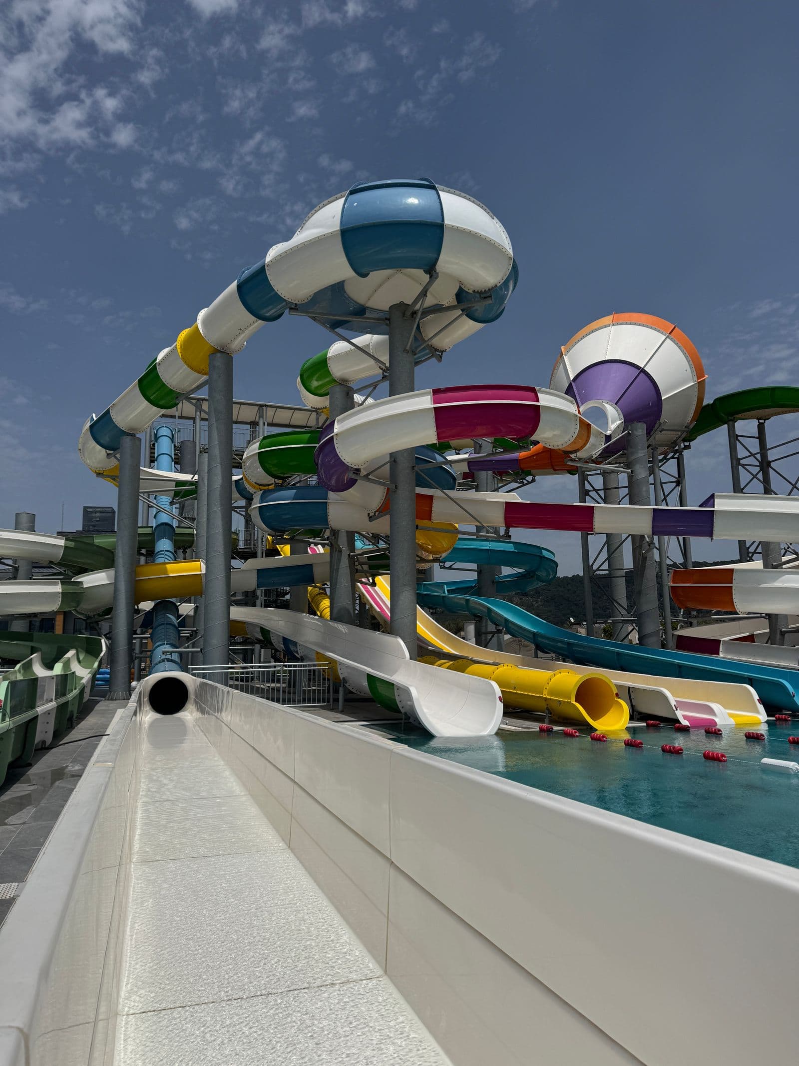Colourful twisting water slides at an outdoor waterpark on a sunny day